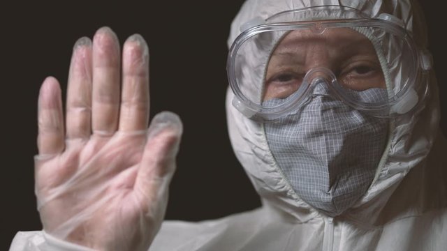 A woman in a white protective medical overalls reports a ban on passage to a closed territory. A number of countries have closed their borders in connection with the coronavirus covid-19 pandemic