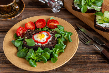 Fototapeta na wymiar Delicious open sandwiches on crusty rye bread with cottage cheese, spinach microgreen, cucumber and baked quail eggs on kitchen board on rustic wooden background