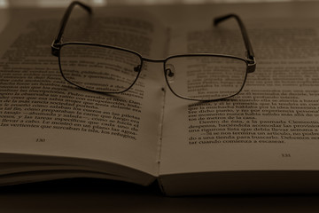 occhiali appoggiati sul libro aperto