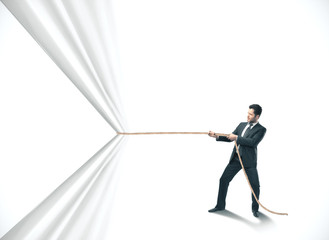 Businessman pulling white curtain with rope