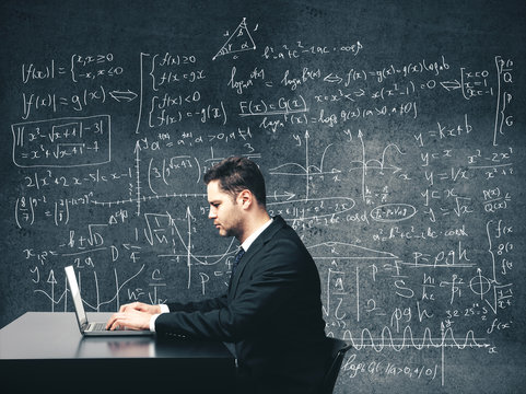 Businessman sitting in office and using laptop