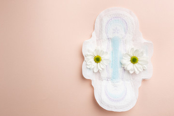 Fototapeta na wymiar White sanitary pad with flowers on it, women's health or body positive concept, top view. Pink background. Flat Lay. Copy Space