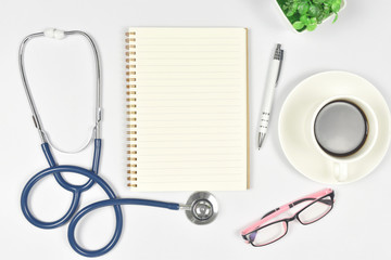 Medical mock-up with blank sheet of paper, clipboard, stethoscope, glasses, heart on doctor desk. Health care concept.