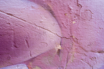 Violet abstract paint on a white cracked wall. Close-up of a graffiti texture. Street art background.