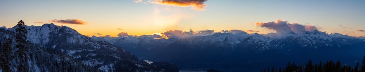 Beautiful Dramatic Canadian Mountain Landscape View during a sunny and cloudy winter sunset. Taken in Squamish, British Columbia, Canada. Nature Background Panorama