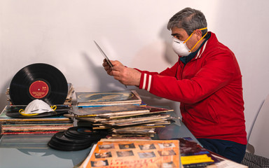 At home for the coronavirus pandemic quarantine COVID-19. Passionate audiophile orders his collection of vinyl