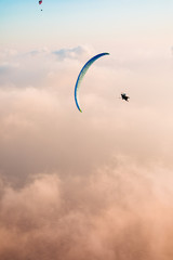 The beauty of paragliding. Extreme sport. Romance of heights. Landscape at sunset. Flying above the clouds.