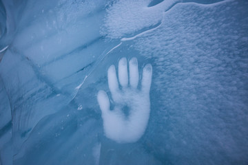 Human Hand Imprint on the Ice Wall in the Natural Cave during winter. Taken in Blackcomb Mountain, Whistler, British Columbia, Canada. Concept: Peace, Humanity, Unity