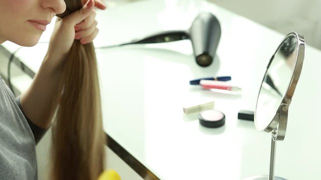 Hair loss. A woman is combing her hair.