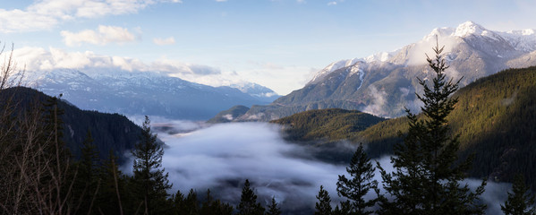 Panoramic Canadian Landscape View of the fog covered valley during a cloudy morning. Taken in Tantalus Lookout near Squamish and Whistler, North of Vancouver, BC, Canada. Background Panorama
