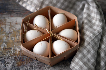 Fresh homemade eggs in a wooden tray. White eggs. Eco products.