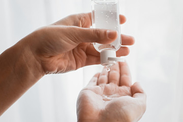 Disinfecting hands. Taking disinfection alcohol gel on hands in white light to prevent virus...