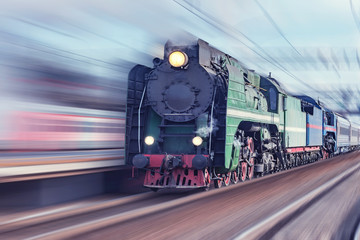 Retro steam train moves fast through the station.