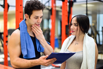 Woman talking to her personal trainer in a gym