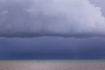 small boat under moody clouds