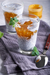Homemade chia pudding with orange jam and mint in a glass
