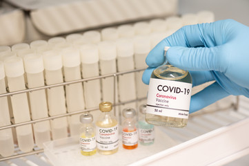Doctor's hand holding bottle vaccine to patient in storage box.Vaccination against coronavirus quarantine or covid-19.Protection against virus and infection control.Medication treatment concept.