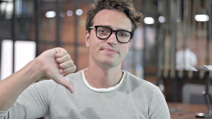 Fototapeta premium Portrait Shoot of Handsome Guy showing Thumbs Down