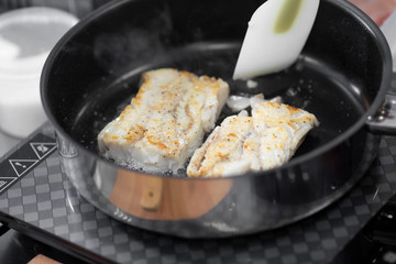 Fish fillet cod white meat fry on parchment in oil in pan