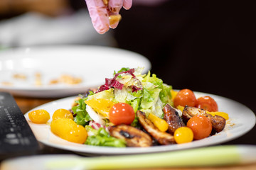 Juicy healthy salad with fried chicken, tomatoes, herbs, oranges, almonds on white plate