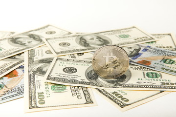 bitcoin coin on the background of one hundred dollars bills.