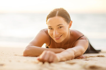 Beautiful woman by the ocean at sunset