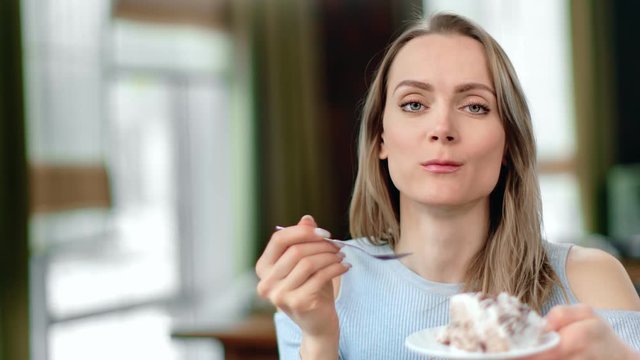 Close up face adorable woman eat appetizing cake using spoon feeling pleasant. 4k Dragon RED camera