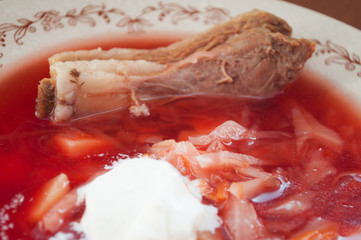 Homemade borsch with sour cream and meat served in a large plate. Homemade food. First course. National food.
