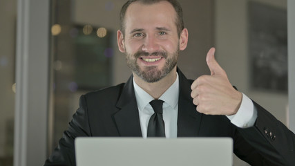 The Close Up of Handsome Businessman showing Thumbs Up at Night