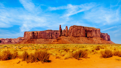 The Three Sisters and Mitchell Mesa, a few of the many massive Red Sandstone Buttes and Mesas in Monument Valley, a Navajo Tribal Park on the border of Utah and Arizona, United States