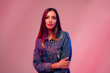 Beautiful caucasian girl in a denim jacket posing in the studio on a white background.