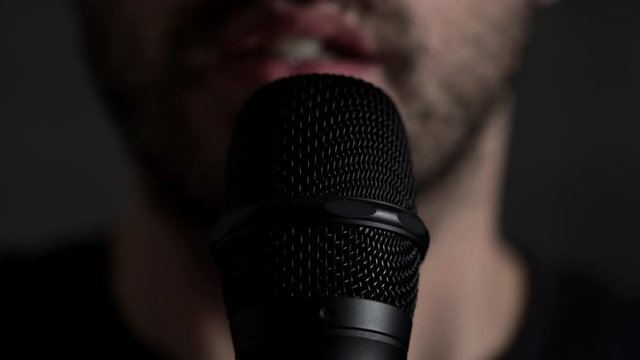 Young bearded Man Talks To Microphone. Man microphone speech, close up front view