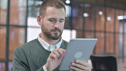 Portrait Shoot of Ambitious Man Scrolling on Tablet