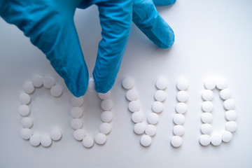 лекарства доктор раскладывает таблетки на белом фоне