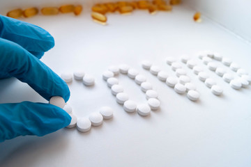 лекарства доктор раскладывает таблетки на белом фоне