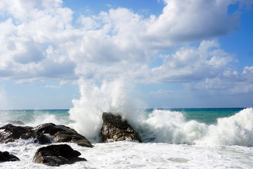 Sea waves bouncing onto rocks creating shower of water droplets