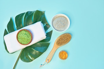 spa massage clay powder, face masks, bath salt, towel, shea butter on blue table background.
