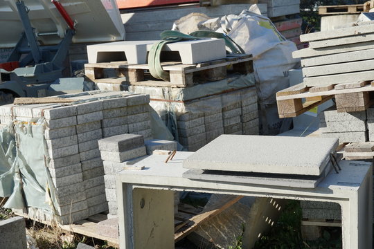 Concrete plates or cobble stones of large dimension piled on wooden pallets in the storage of building or construction material