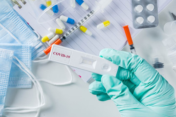 Fototapeta premium Worldwide coronavirus epidemic concept. Pandemic COVID-19, 2019-nCoV. Laboratory test strip for antibody or sars-cov-2 virus disease. In doctor hands. With pills, vaccination syringes, notebook.