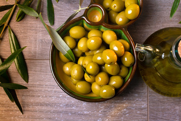 Aceitera con aceite de oliva virgen y aceitunas verdes frescas vista cenital - obrazy, fototapety, plakaty