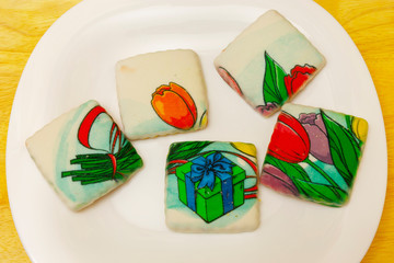 Cookies covered with icing are on the plate.