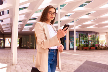 Young businesswoman using her mobile phone and text messaging