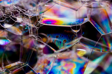 Macro photography of various soap bubbles creating different geometric shapes with striking colors, selective focus