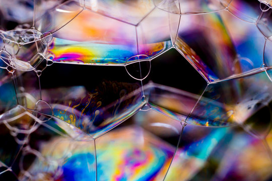 Macro photography of various soap bubbles creating different geometric shapes with striking colors, selective focus