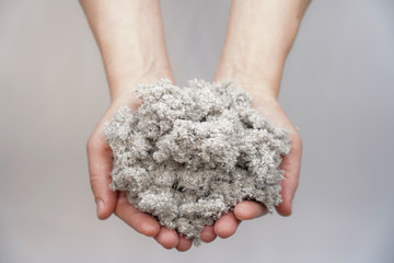 Hands holding cellulose fiber for ecological insulation of the house. Conservation of home heat and...