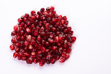 Pile of fresh pomegranate seeds isolated on white. Red healthy fruit. Top view. Food and healthy lifestyle concept. Copy space...