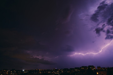 Fototapeta premium City view at night under thunderstorm with strike of lightning. Bad weather. 