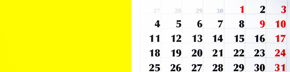 Macro calendar from different angles on a yellow and pink background. Black and red numbers on the calendar.  Copy Space