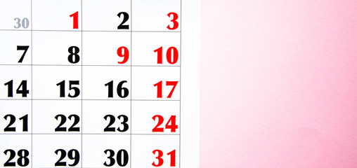 Macro calendar from different angles on a yellow and pink background. Black and red numbers on the calendar.  Copy Space