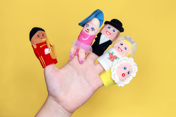 Puppet theater. Hand wearing finger family members puppets: mum, dad, grandmother, grandfather,...
